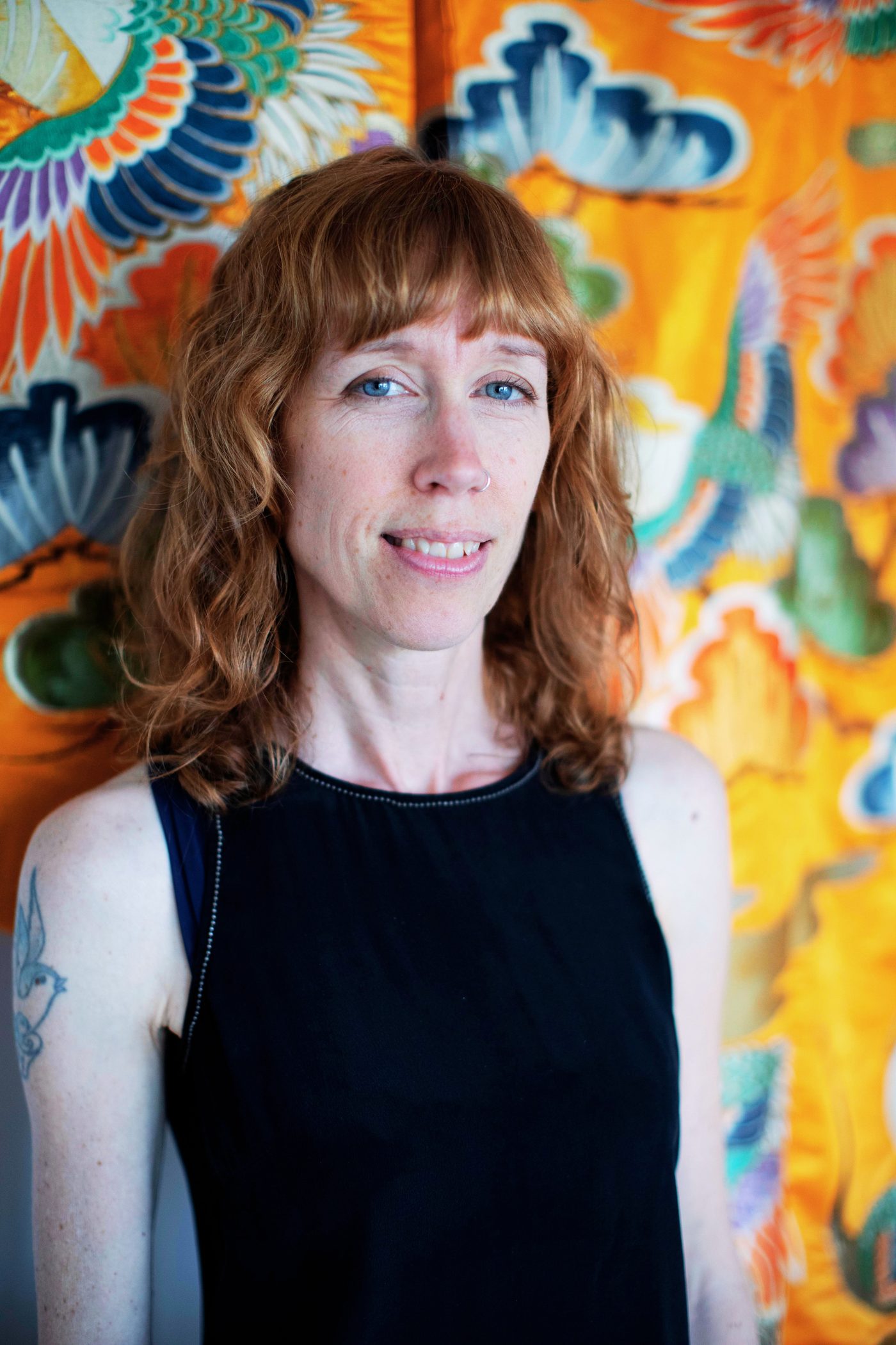 Lara Kehler in front of a brightly patterned mural